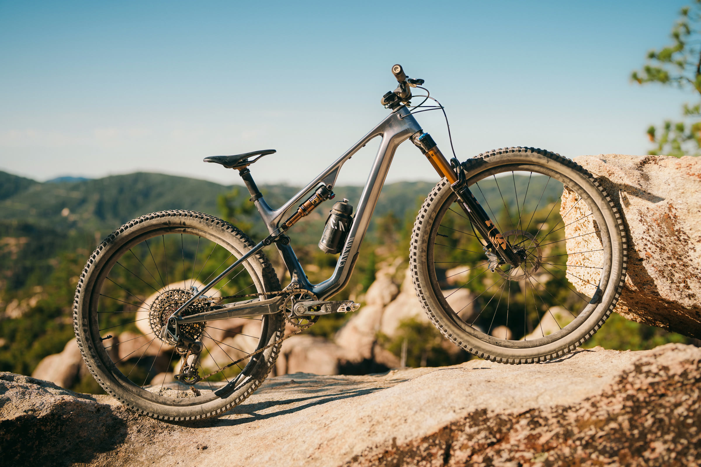 Mountainbike auf einem Granitfelsen über einem bewaldeten Tal